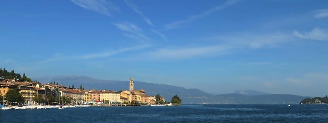 Trip Formentera beliebte Urlaubsziele am Gardasee -  Mit einer Fläche von 370 km² ist der Gardasee der größte See Italiens. Es liegt am Fuße der Alpen und erstreckt sich über drei Staaten: Lombardei, Venetien und Trentino. Die maximale Tiefe des Sees beträgt 346 m, er hat eine längliche Form und sein nördliches Ende ist sehr schmal. Dort ist der See von den Bergen der Gruppo di Baldo umgeben. Du trittst aus deinem gemütlichen Hotelzimmer und es begrüßt dich die warme italienische Sonne. Du blickst auf den atemberaubenden Gardasee, der in zahlreichen Blautönen schimmert - von tiefem Dunkelblau bis zu funkelndem Türkis. Majestätische Berge umgeben dich, während die Brise sanft deine Haut streichelt und der Duft von blühenden Zitronenbäumen deine Nase kitzelt. Du schlenderst die malerischen, engen Gassen entlang, vorbei an farbenfrohen, blumengeschmückten Häusern. Vereinzelt unterbricht das fröhliche Lachen der Einheimischen die friedvolle Stille. Du fühlst dich wie in einem Traum, der nicht enden will. Jeder Schritt führt dich zu neuen Entdeckungen und Abenteuern. Du probierst die köstliche italienische Küche mit ihren frischen Zutaten und verführerischen Aromen. Die Sonne geht langsam unter und taucht den Himmel in ein leuchtendes Orange-rot - ein spektakulärer Anblick.